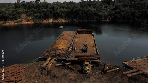 Barge trailers on the banks of the Tocantins River to transport logs cut down in the Amazon rainforest - aerial view photo