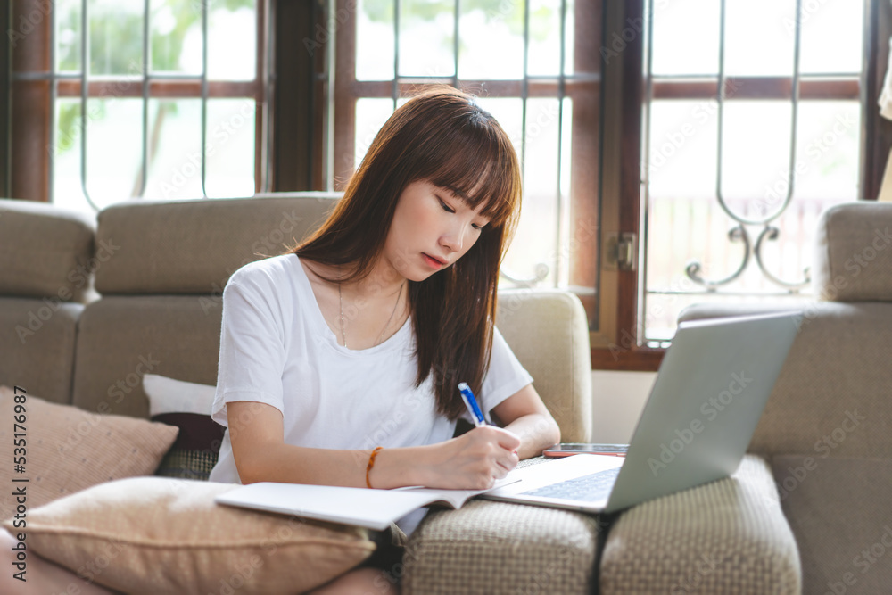 Young adult asian woman student using laptop computer for online technology at cozy place sofa home Young adult asian woman student using laptop computer for online technology at cozy place sofa home