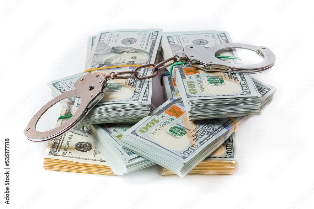 A dollars in bundles on white background with handcuffs crime fraud concept business pandemic A dollars in bundles on white background with handcuffs crime fraud concept business pandemic