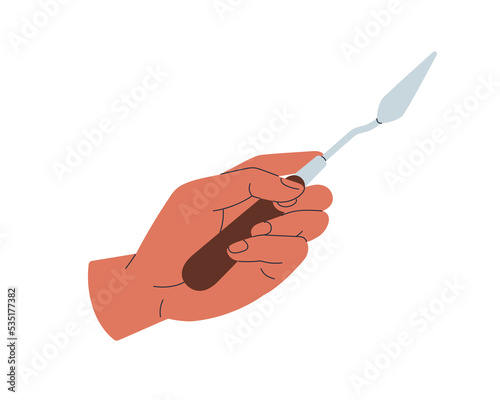 Hand holding painting knife for oil paint. Artists arm, wrist with painters t...