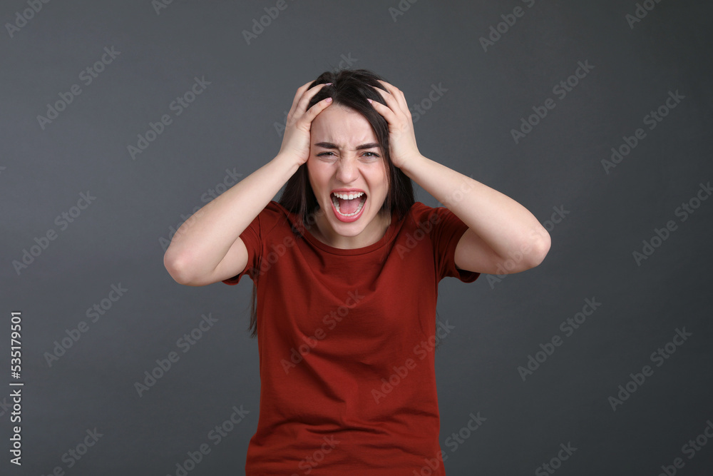 Portrait of emotional young woman on dark grey background. Personality concept Portrait of emotional young woman on dark grey background. Personality concept