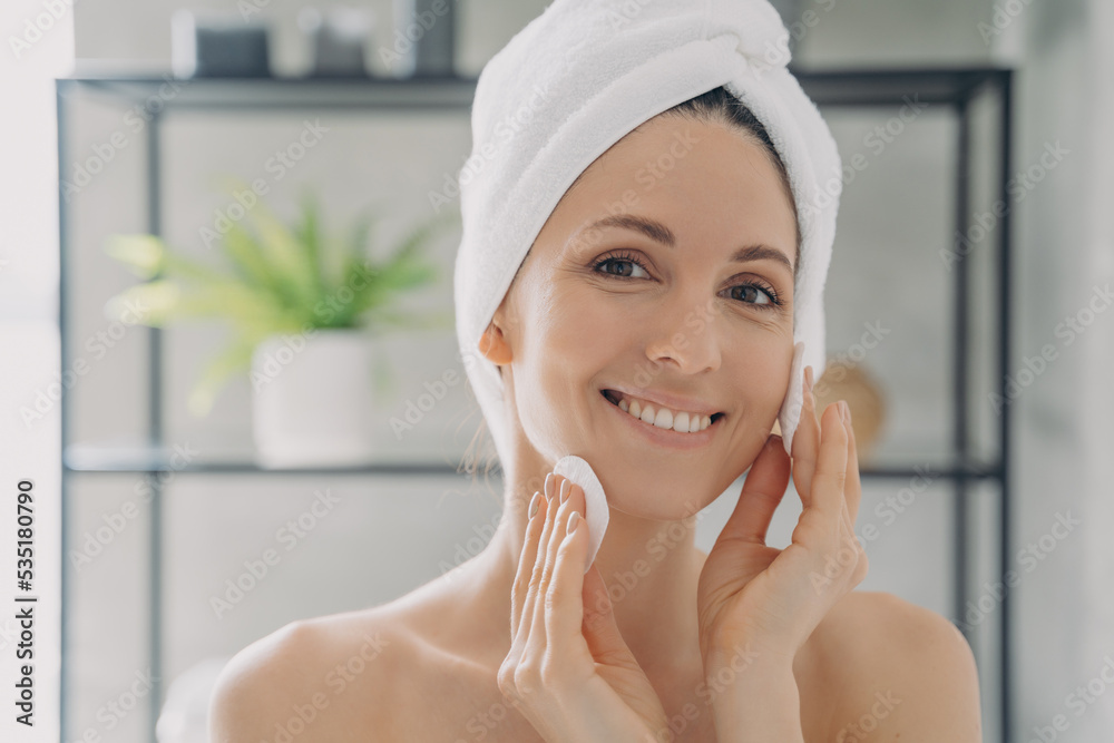 Hispanic woman cleansing facial skin with cotton pads after shower removing makeup. Skincare routine Hispanic woman cleansing facial skin with cotton pads after shower removing makeup. Skincare routine