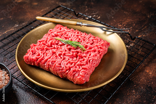 Fresh Raw mince beef, ground meat in a steel plate. Dark background. Top view