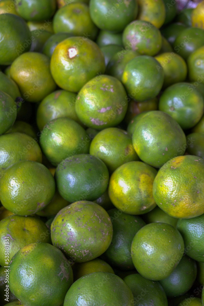 Close up of fresh green orange. Bunch of green lemon at market Close up of fresh green orange. Bunch of green lemon at market