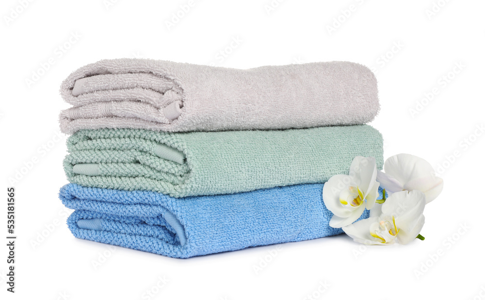 Stack of clean soft towels with orchids isolated on white Stack of clean soft towels with orchids isolated on white