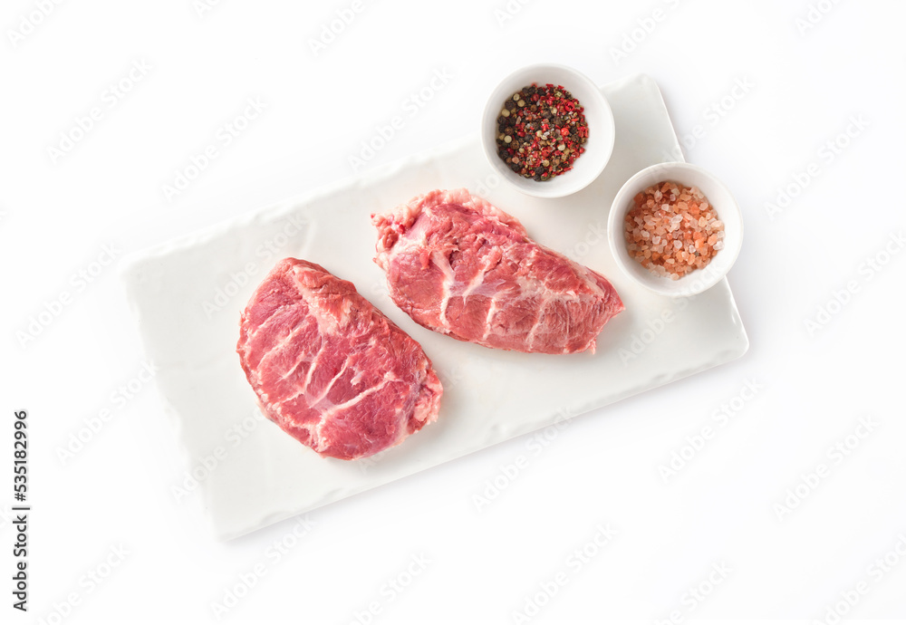 Raw fresh pork cheeks with salt and pepper on a white background Raw fresh pork cheeks with salt and pepper on a white background