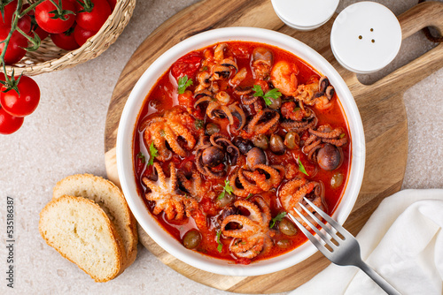 Italian or Greek-style braised octopus stew with tomato sauce, garlic and olives. Polipetti affogati alla Luciana photo