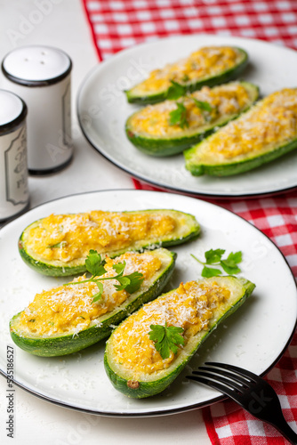 Baked Zucchini boats stuffed with ricotta cheese, tuna fish, egg, bread crumbs and parmesan cheese. Vertical image.