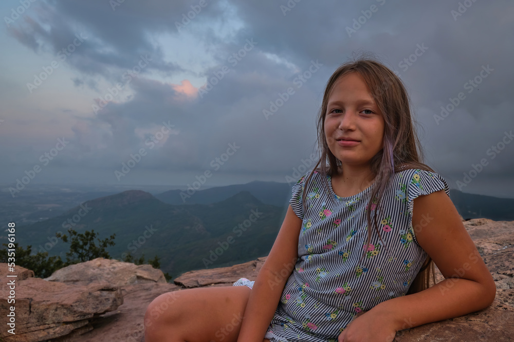 portrait of a girl against the sky and mountains