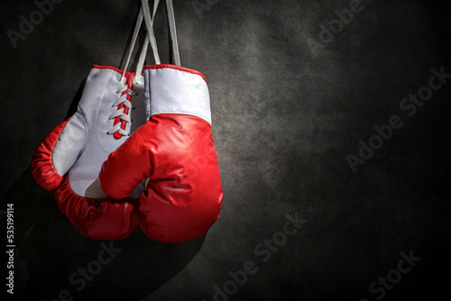 Boxing gloves hanging on wall with grunge gray background and copy space © Brian Jackson
