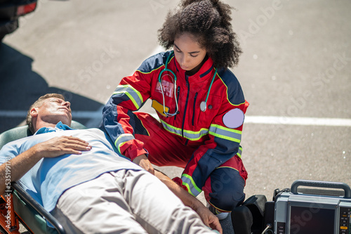 EMT strapping the patient to the stretcher photo