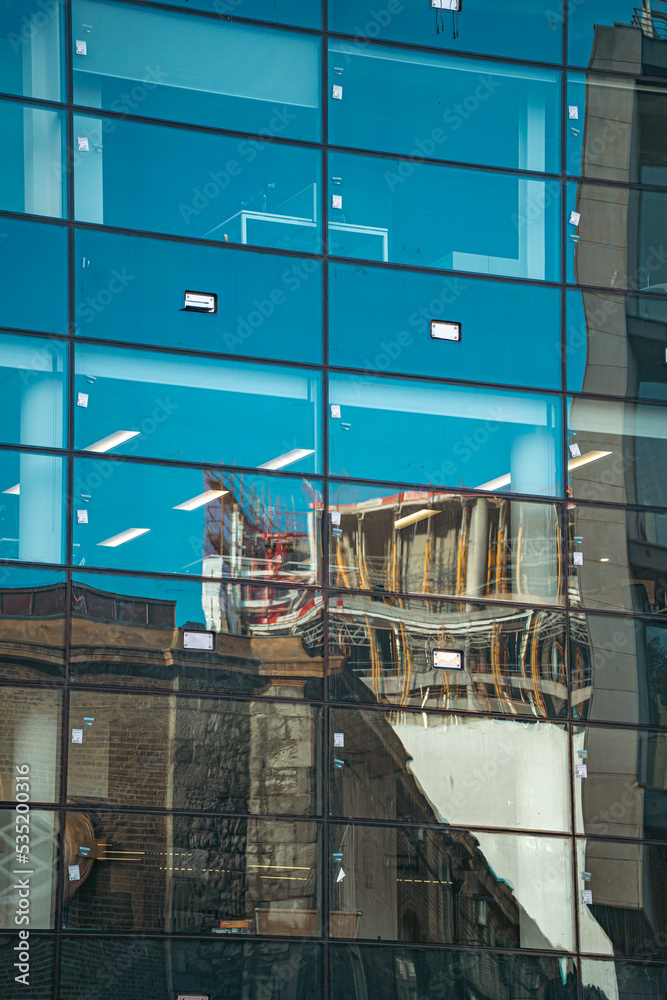 Reflection of old architecture in new office building with windows