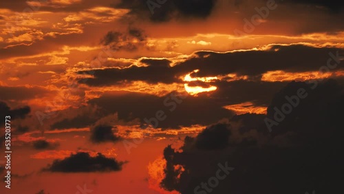 Timelapse image of light beams among clouds in a gloomy sky covered with rain and storm clouds.