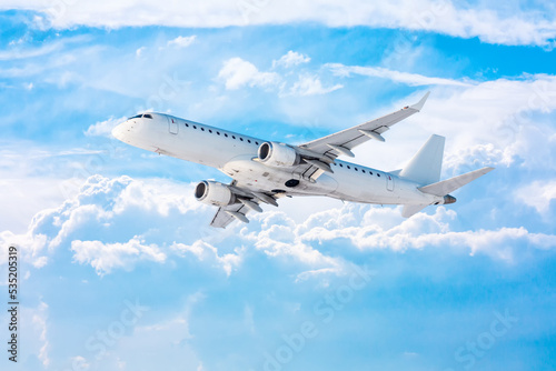 White passenger airplane fly in the picturesque sky