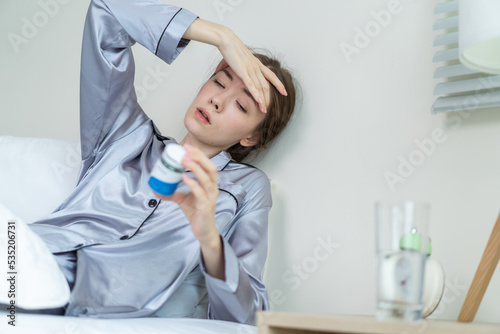 Caucasian beautiful sick woman in pajamas taking medicine before sleep.
