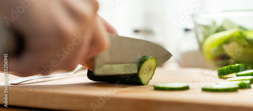 Close up of Young Caucasian woman cook green salad in kitchen at home. 
