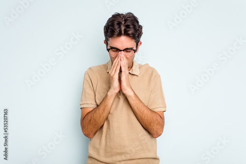 Fotografie, Obraz Young hispanic man isolated on blue background praying, showing devotion, religious person looking for divine inspiration