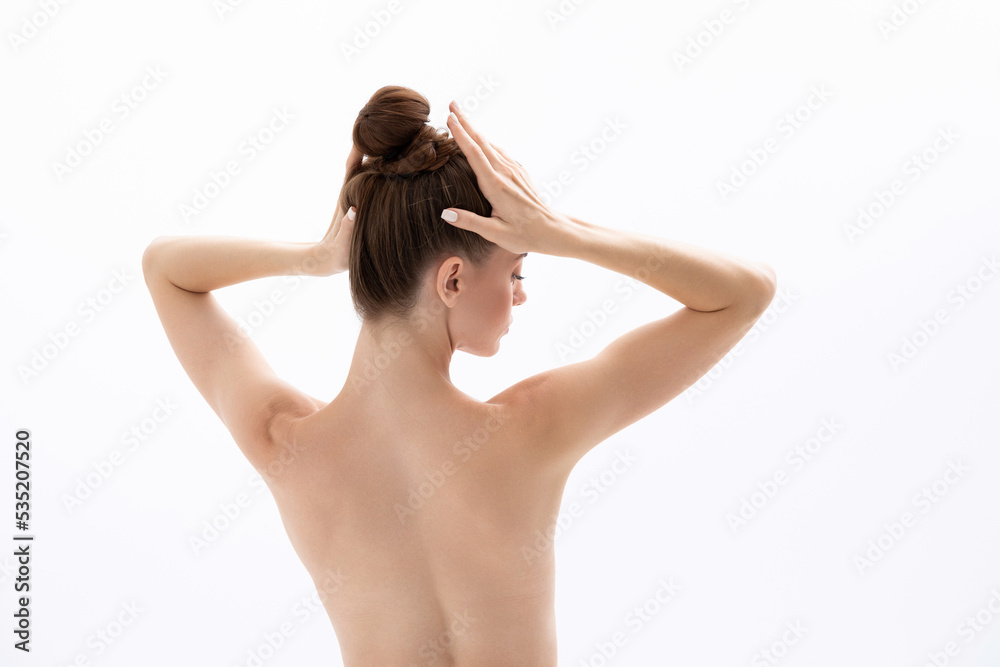 A young woman touches her head and demonstrates products for hair and skin. A young woman touches her head and demonstrates products for hair and skin.