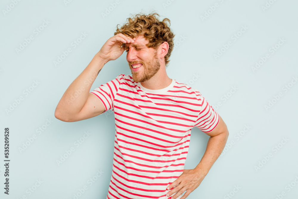 Young caucasian man isolated on blue background joyful laughing a lot. Happiness concept.