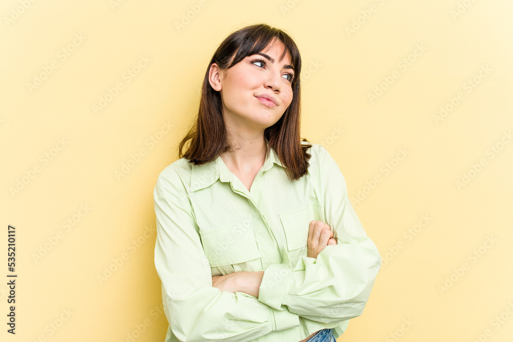 Young caucasian woman isolated on yellow background dreaming of achieving goals and purposes