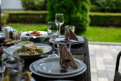 A table with beautiful dishes and prepared dishes on the summer terrace