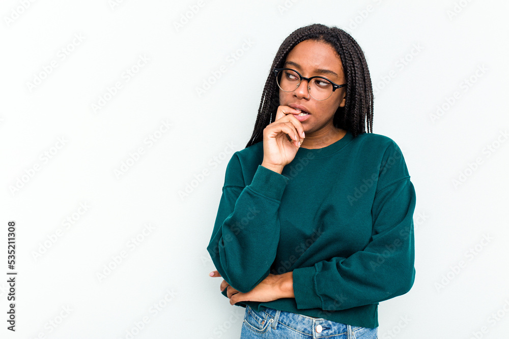 Young African American woman isolated on white background relaxed thinking about something looking at a copy space.