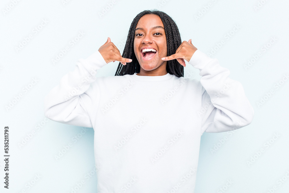 Young African American woman with braids hair isolated on blue background showing a mobile phone call gesture with fingers. Young African American woman with braids hair isolated on blue background showing a mobile phone call gesture with fingers.