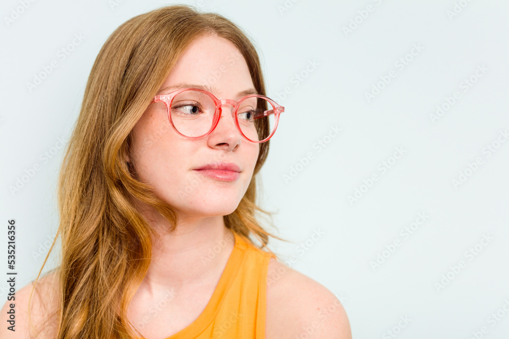 Portrait of pretty young caucasian wearing glasses woman isolated on blue background