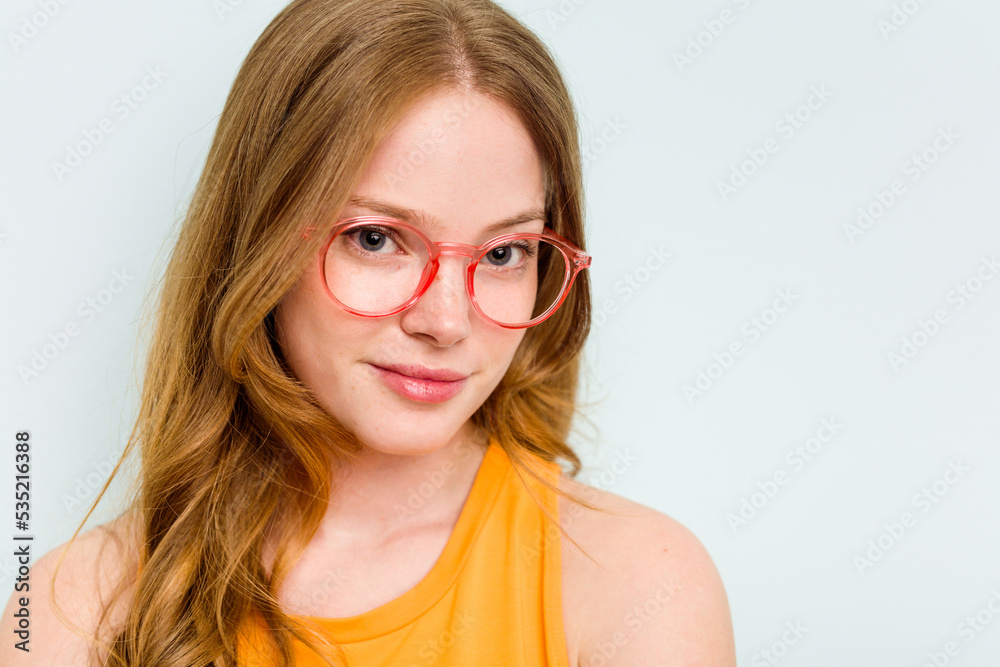 Portrait of pretty young caucasian wearing glasses woman isolated on blue background