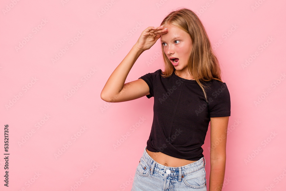 Caucasian teen girl isolated on pink background looking far away keeping hand on forehead. Caucasian teen girl isolated on pink background looking far away keeping hand on forehead.