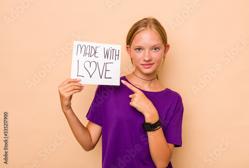 Little caucasian girl holding made with love placard isolated on beige background