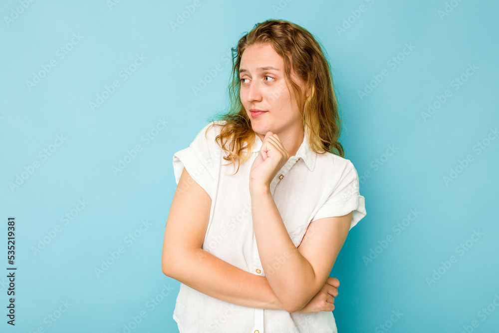 Young caucasian woman isolated on blue background confused, feels doubtful and unsure.
