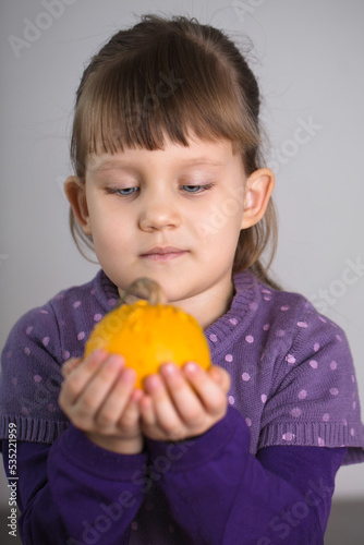 girl holds a pumpkin in her hands
