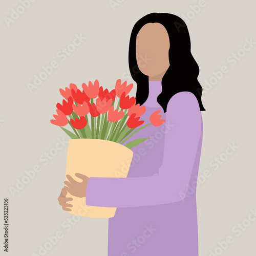 Beautiful woman holding a large bouquet of tulips in her hands