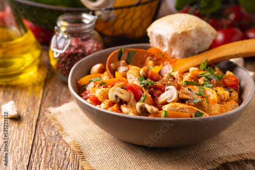 Chicken stew with peppers, mushrooms and tomatoes.