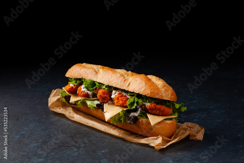 Canvastavla Chicken sandwich in breadcrumbs. A long roll. Dark mood.