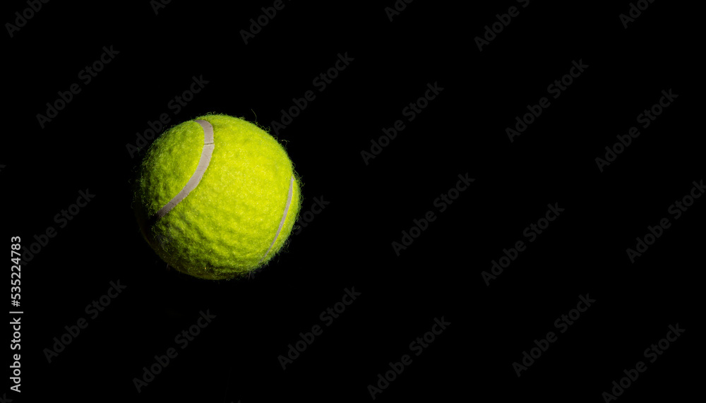 Tennis ball hanging on dark background banner - sports concept