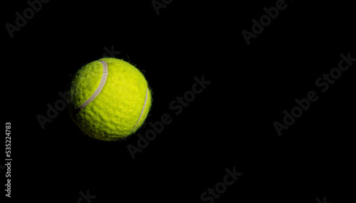Tennis ball hanging on dark background banner - sports concept © stockyme