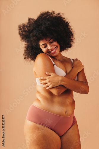 Beautiful plus size woman embracing her naked body in a studio © (JLco) Julia Amaral