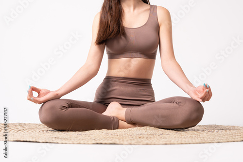 Young woman sitting in lotus pose.