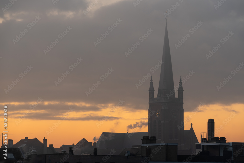 Jette, Brussels Capital Region - Belgium - Colorful foggy clouds and skyline with church tower