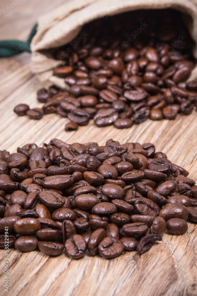 Fototapeta premium Dark roasted fragrant coffee beans in jute bag