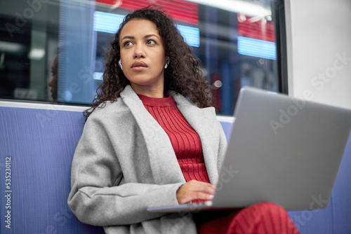 Obraz na płótnie young woman with a laptop traveling in the subway. w salonie