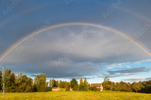 Rural landscape with double rainbow, autumn day after rain