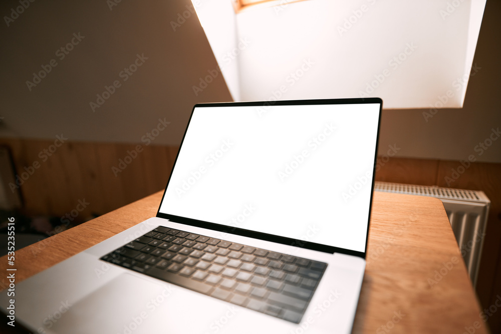 Aluminum professional laptop with empty screen open in modern interior. Concept of work from home. Blank screen notebook mock-up. Aluminum professional laptop with empty screen open in modern interior. Concept of work from home. Blank screen notebook mock-up.