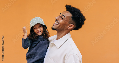 Happy young dad celebrating father's day with his daughter in a studio photo