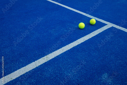 balls on a blue paddle tennis court © Vic