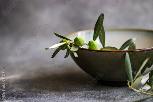 Close-Up of olive branches with olives in a ceramic bowl