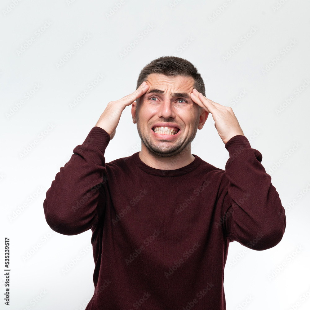 Naklejka premium Handsome man wearing casual sweater feeling tired and headache, Stress and headache concept.