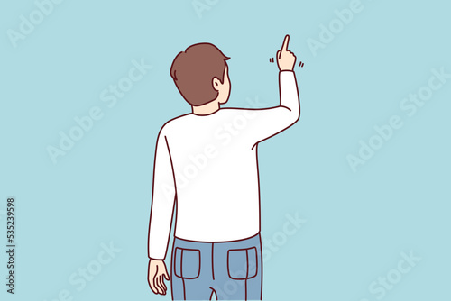 Back view of man pointing at wall with finger. Guy showing with finger on blank space. Vector illustration. 